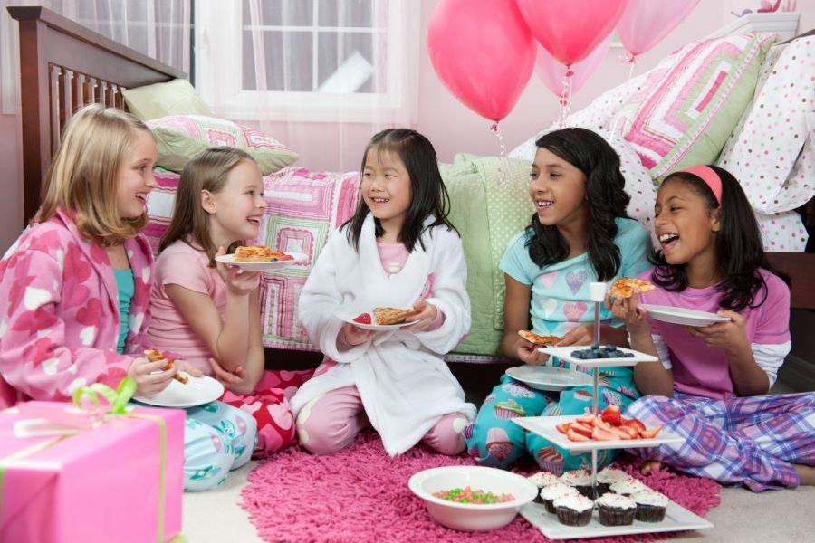 Five girls having a sleepover party.