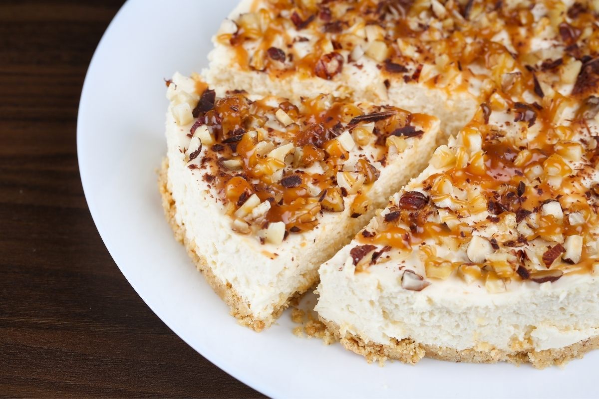 Detail of easy coconut cheesecake decorated with caramel and assorted nuts.