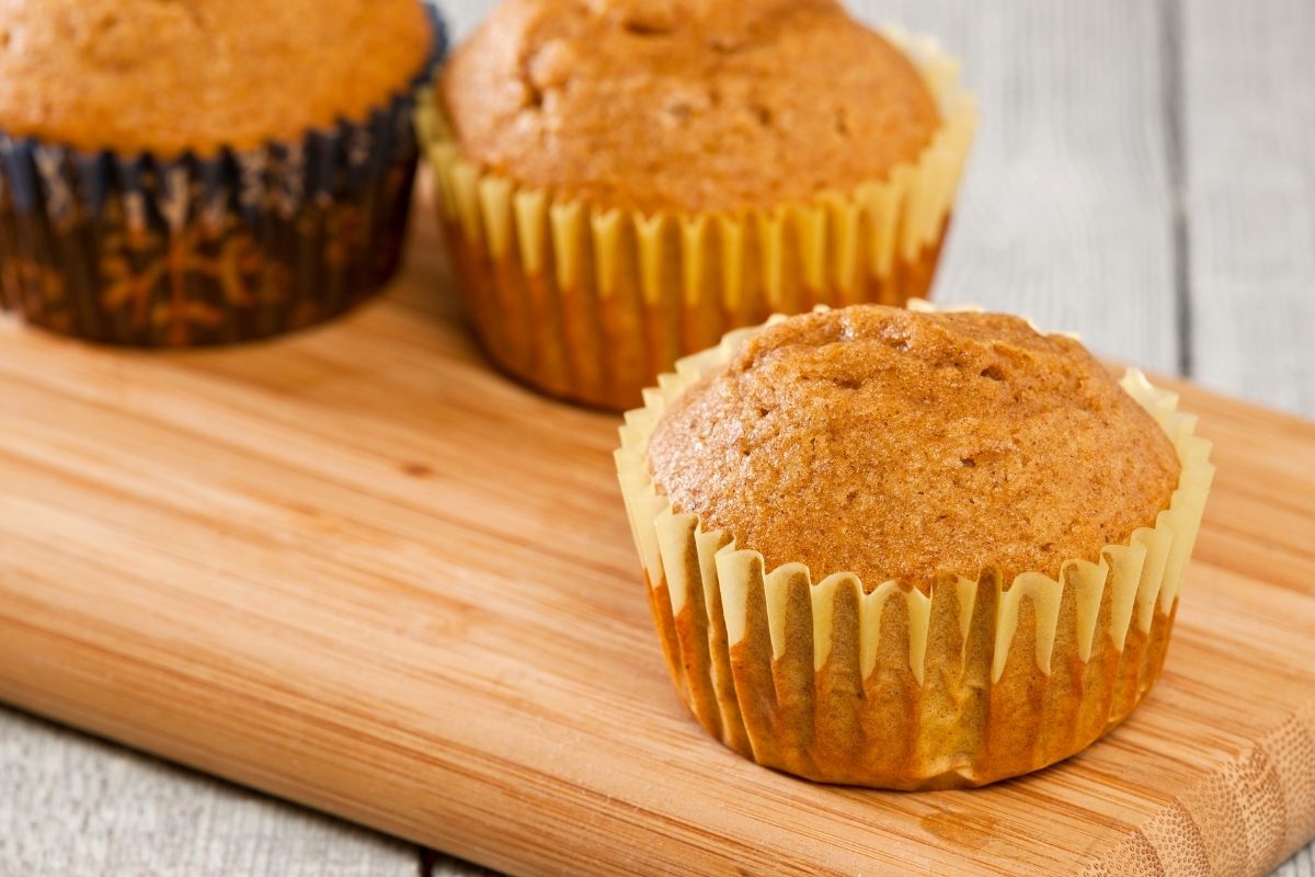 Freshly baked simple pumpkin muffins on a cutting board.