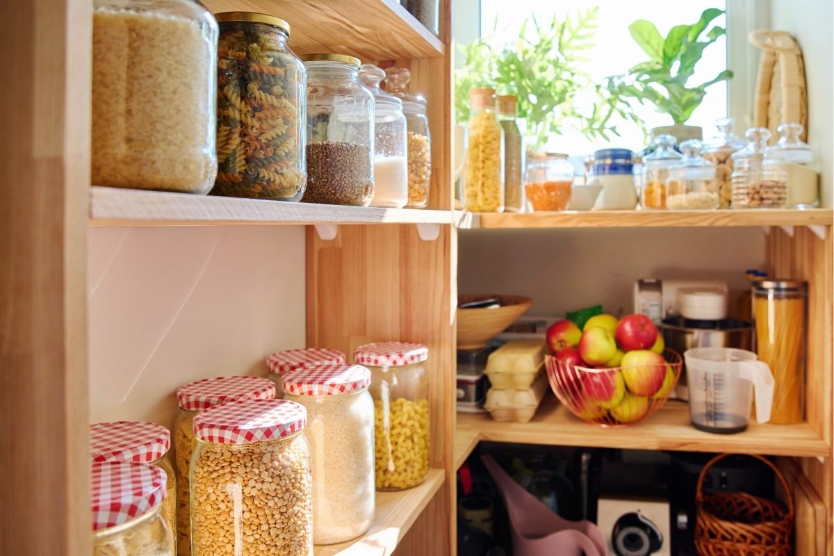 Food in the pantry on wooden shelves.