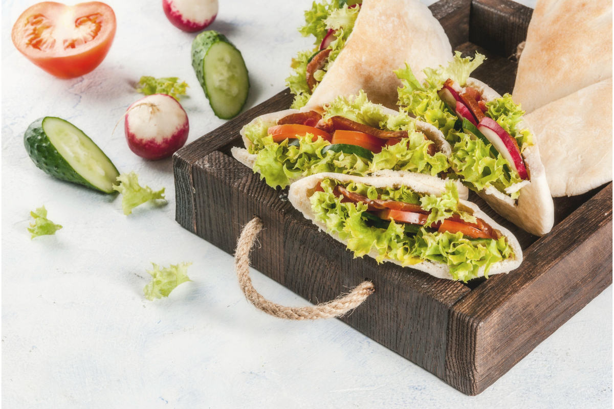 Pita pockets filled with lettuce, tomato and cucumber salad.