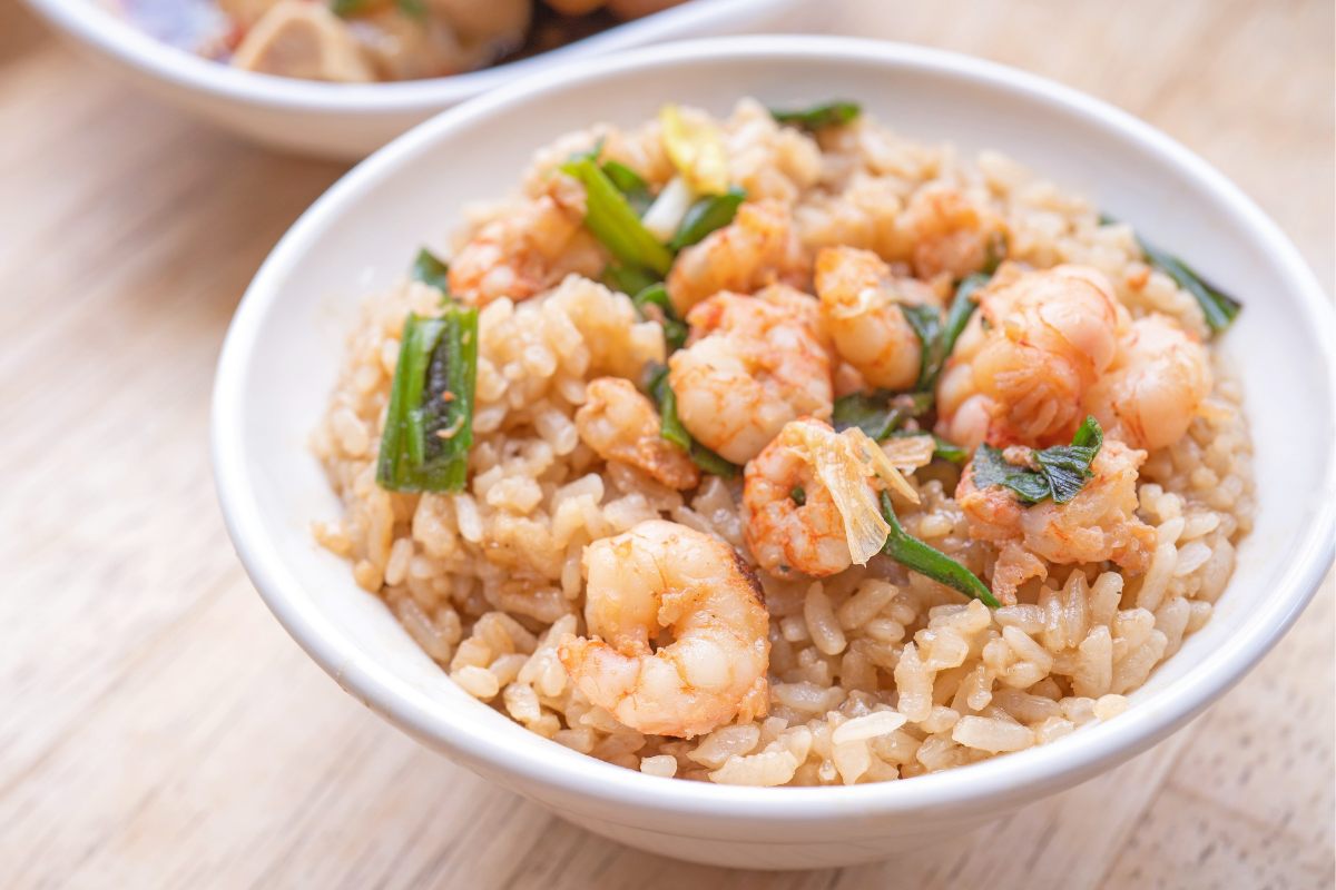 A bowl with cooked shrimp and rice salad.