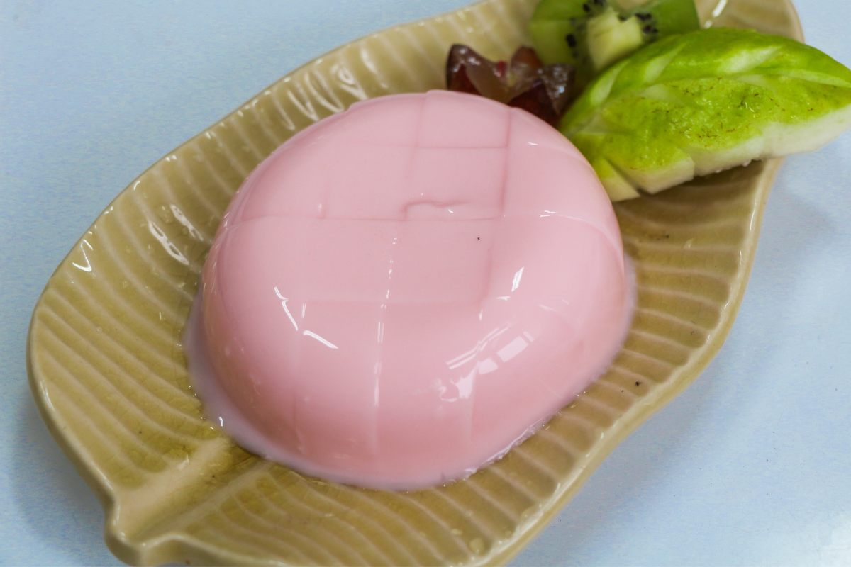 An individual portion of strawberry milk jelly.