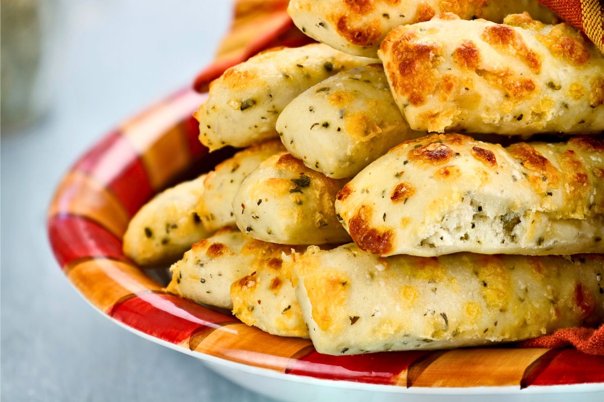 A plate with cheesy breadsticks.