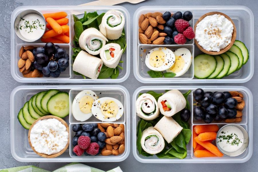 Healthy breakfast, lunch or snack to go with tortilla wraps, eggs, cottage cheese, almonds, fruits and vegetables.