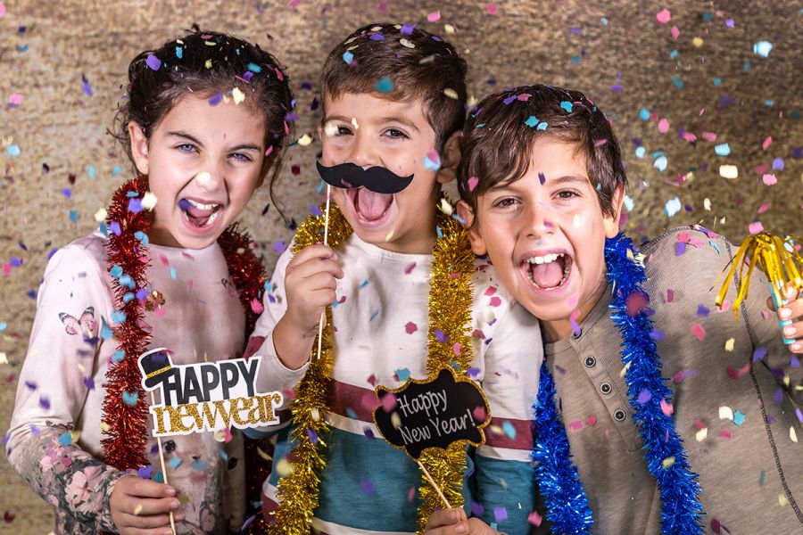 Three kids happily celebrating New Year at home.