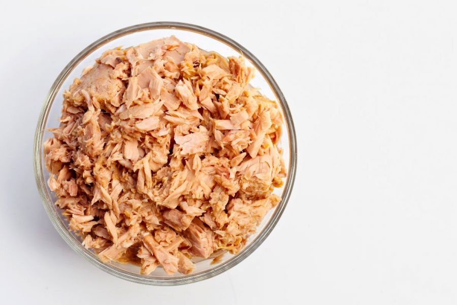 A glass bowl with canned tuna, flaked.